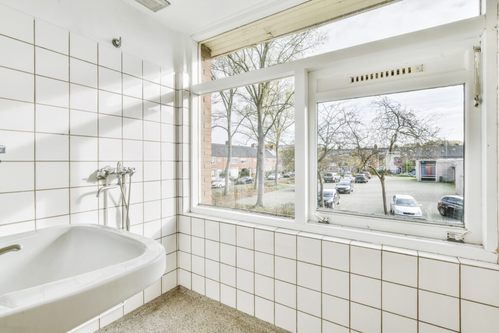 Bathroom with white tiles and a window